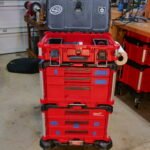 Milwaukee Packout system in a garage, organized with various tool compartments and stickers.