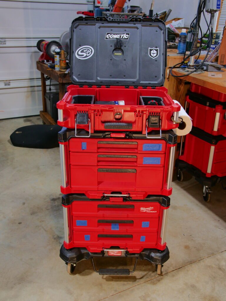 Milwaukee Packout system in a garage, organized with various tool compartments and stickers.
